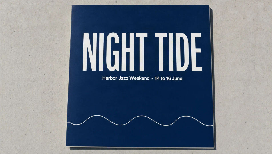 Un cartel de concierto azul profundo con el titular NIGHT TIDE y una línea más pequeña con los datos del evento, sobre concreto