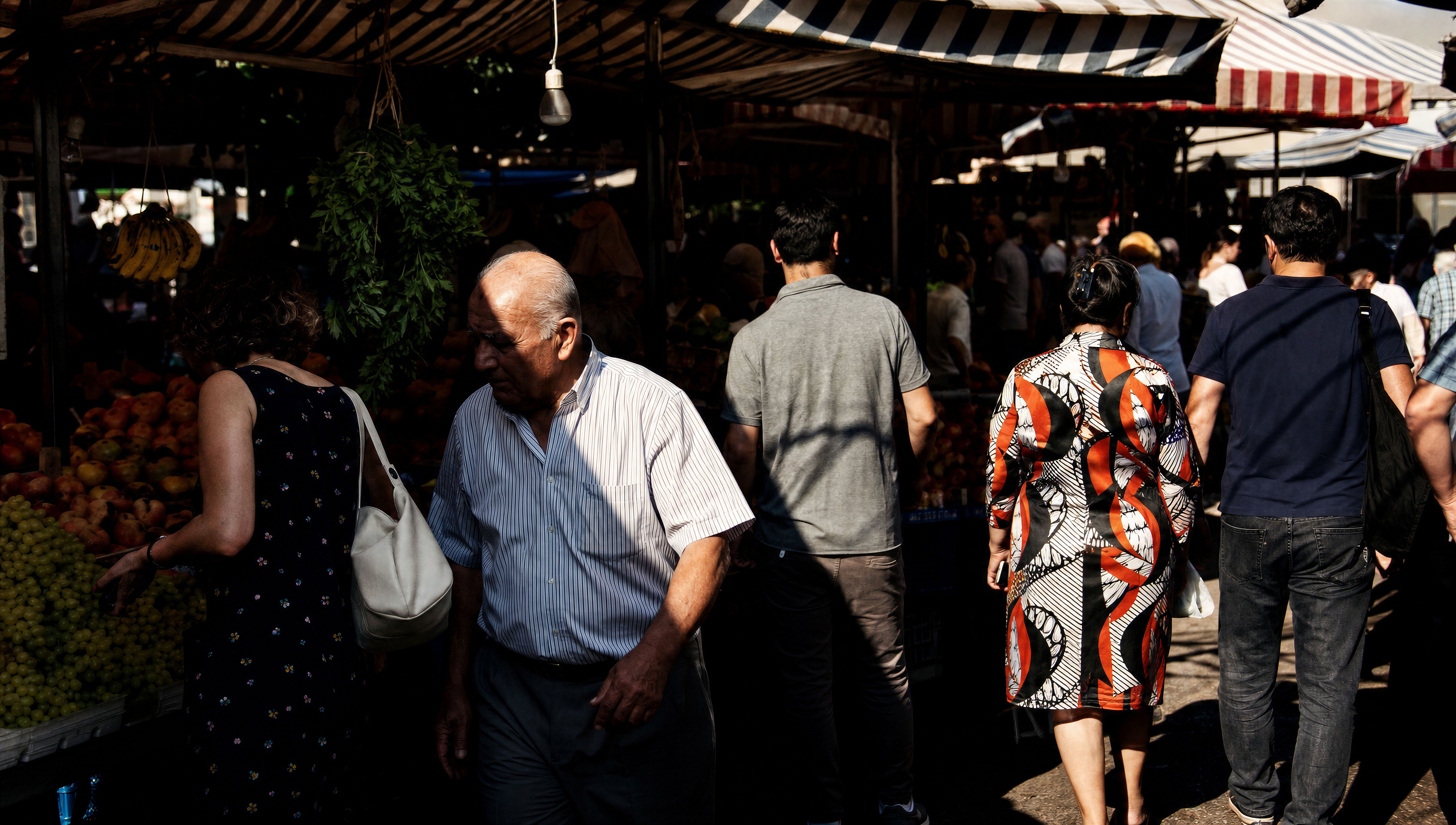 Sunlit market street with hard shadows