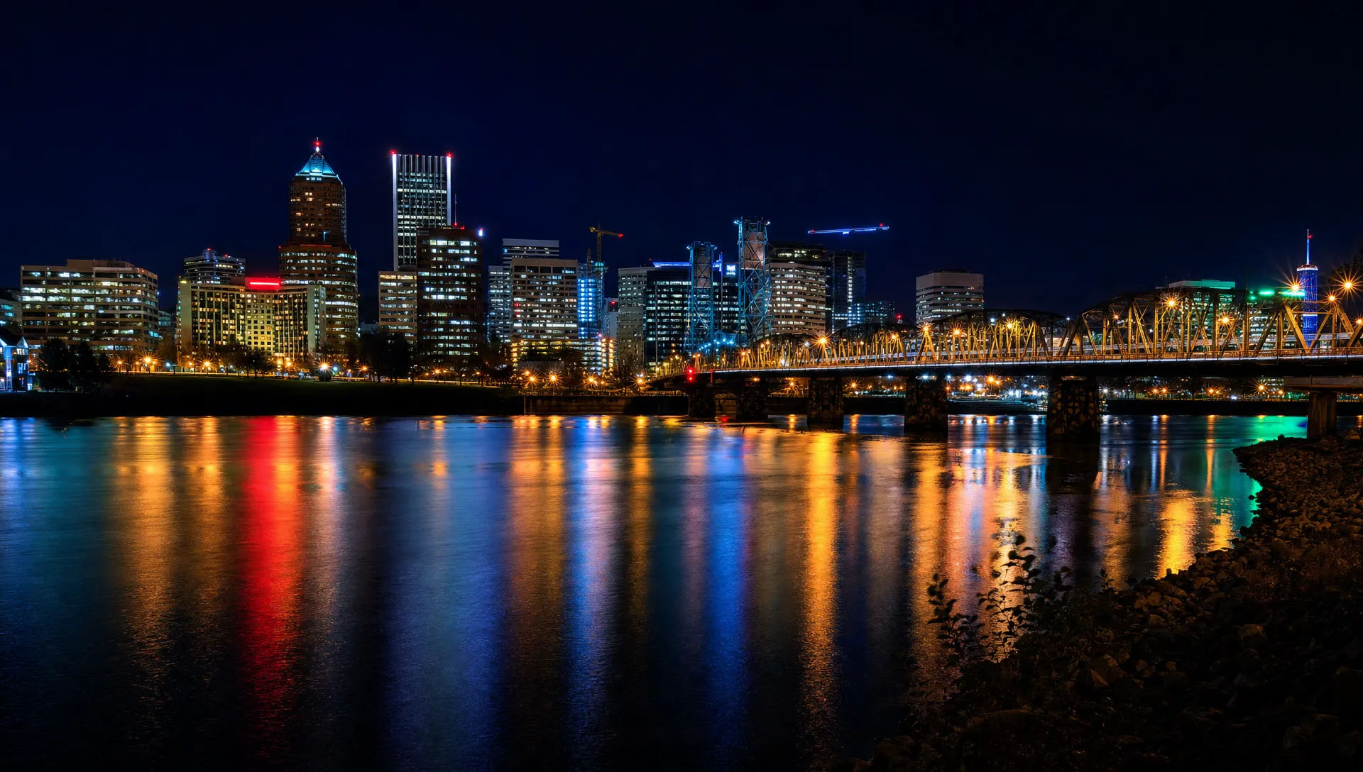 Glowing skyline across a dark river