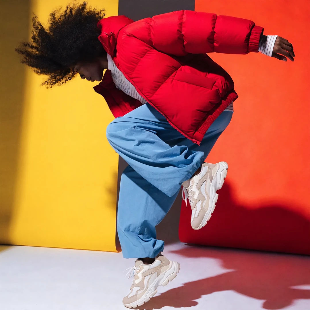 Athletic wear campaign hero in a dynamic pose with editorial light