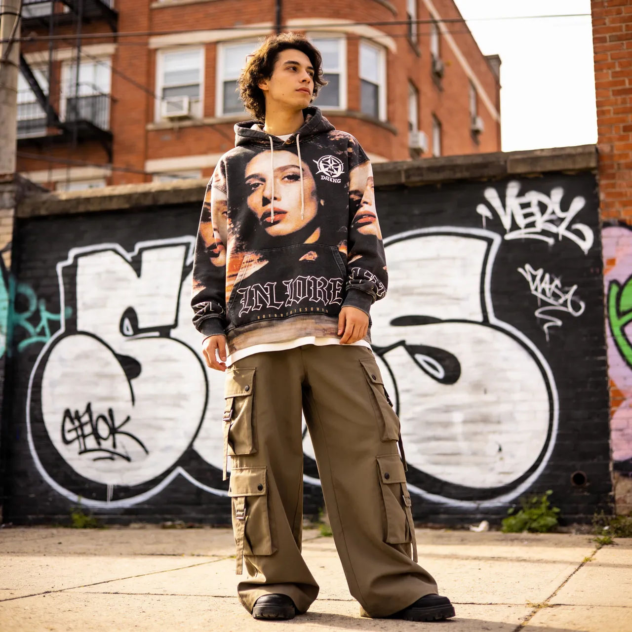 Oversized hoodie and cargo pants streetwear look on an urban backdrop