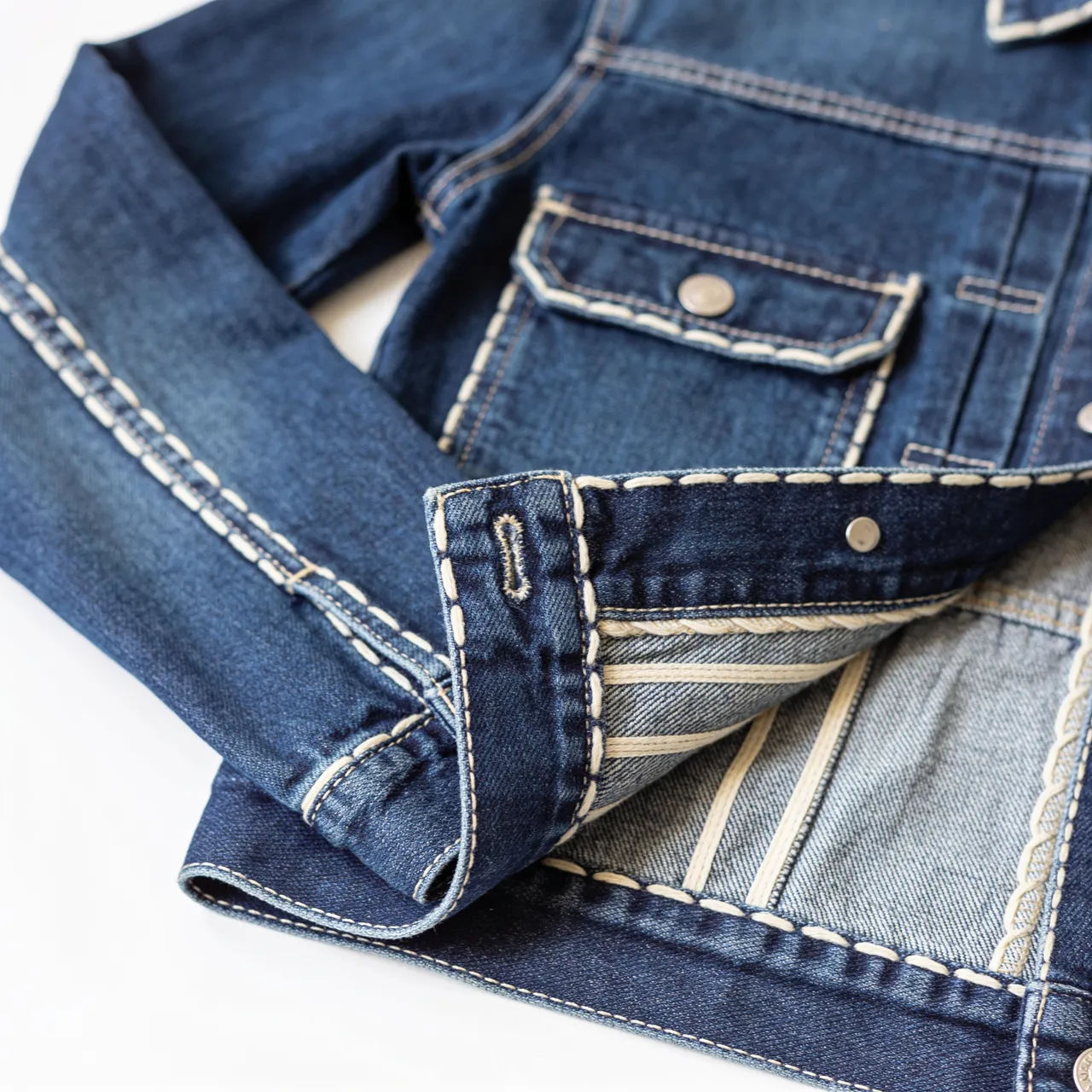 Washed indigo denim jacket product flat lay on a clean white background