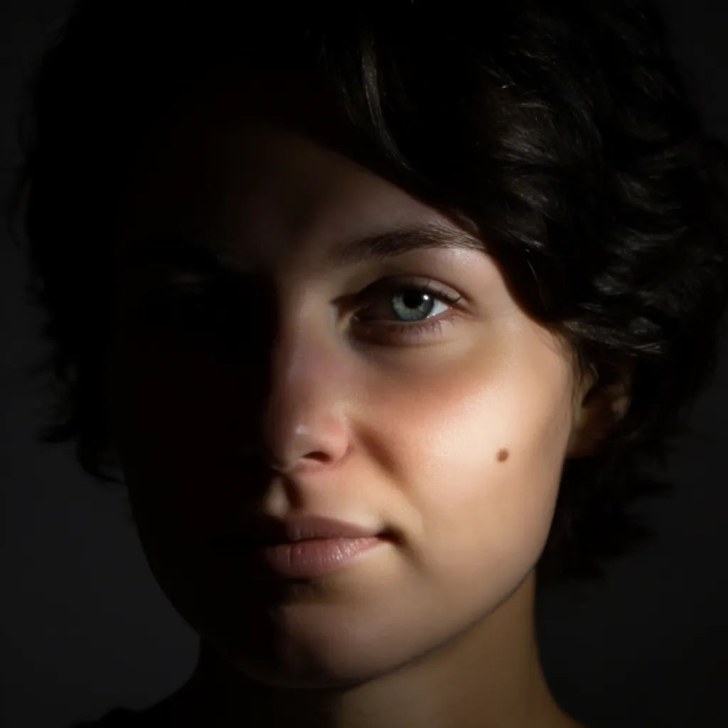 Headshot relit as dramatic low-key with one hard side light