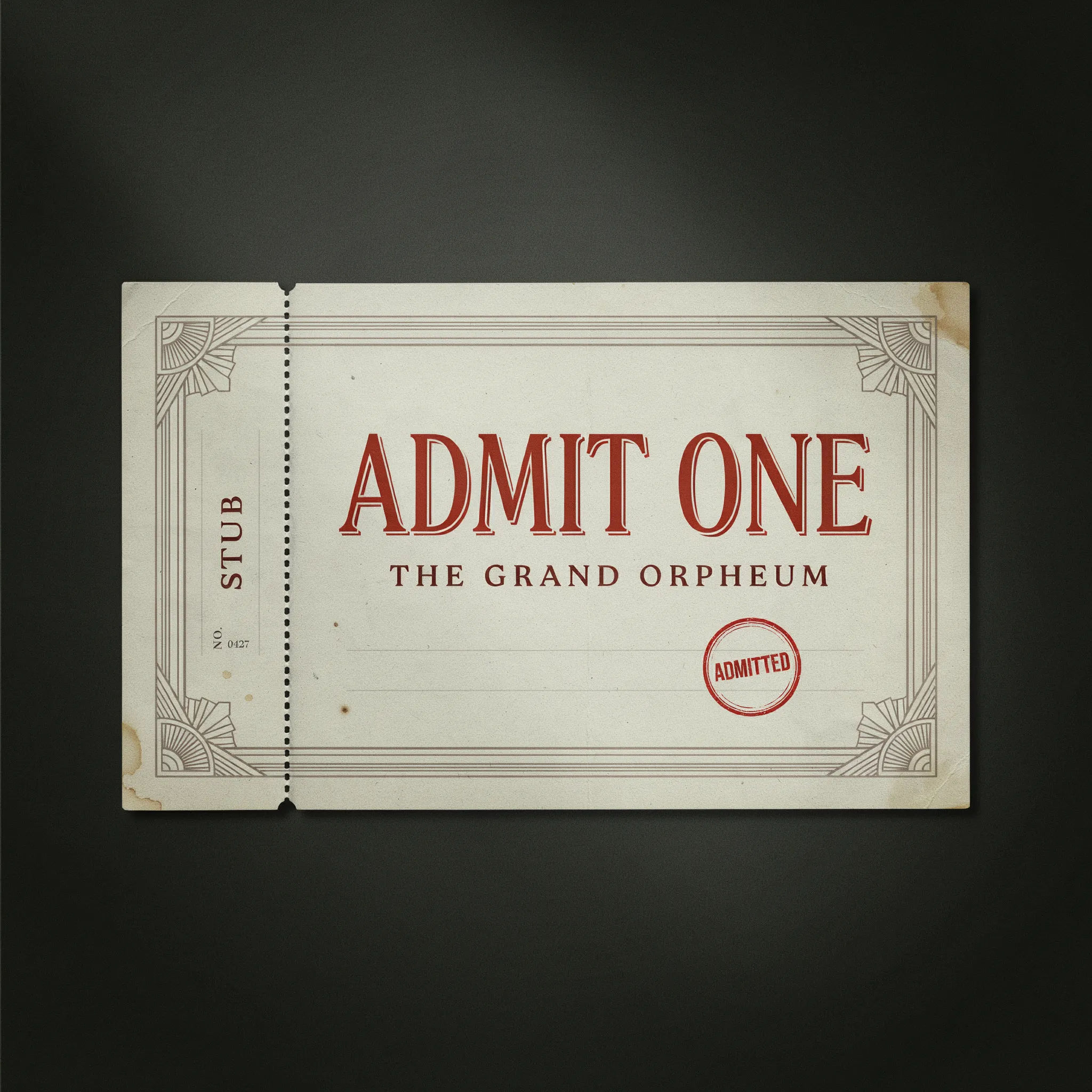 Vintage admit-one cinema ticket on aged cream paper with deco type