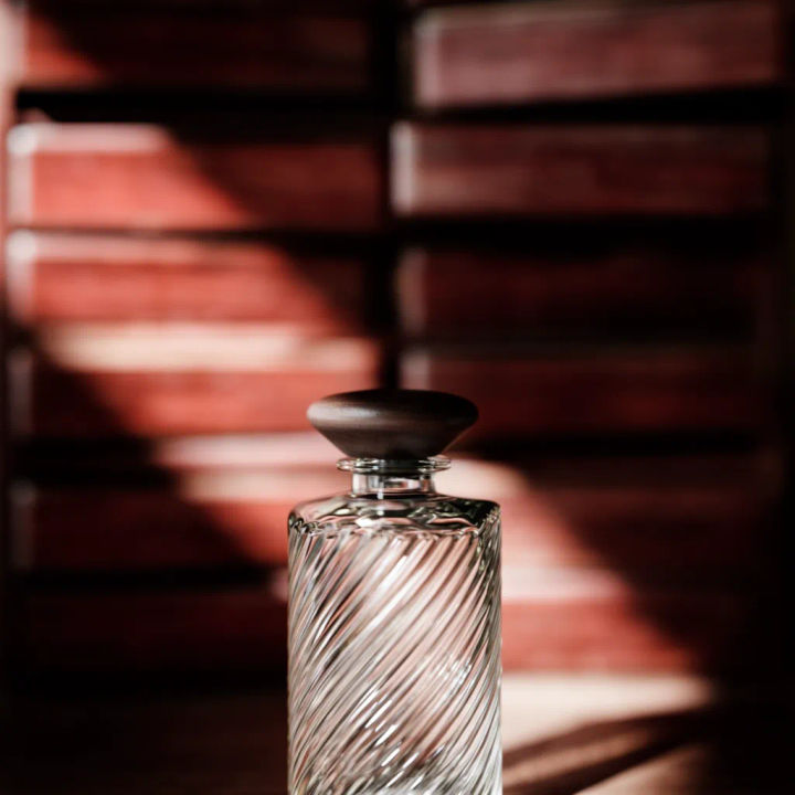 Frasco de perfume em foco com a prateleira ao redor suavizada