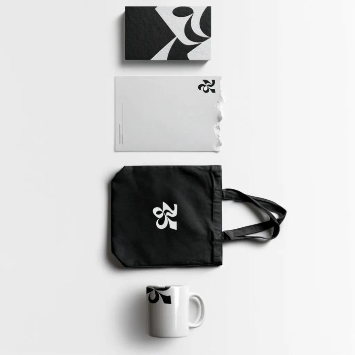 Flat lay visto de cima com cartão, papel timbrado, ecobag e caneca com a marca