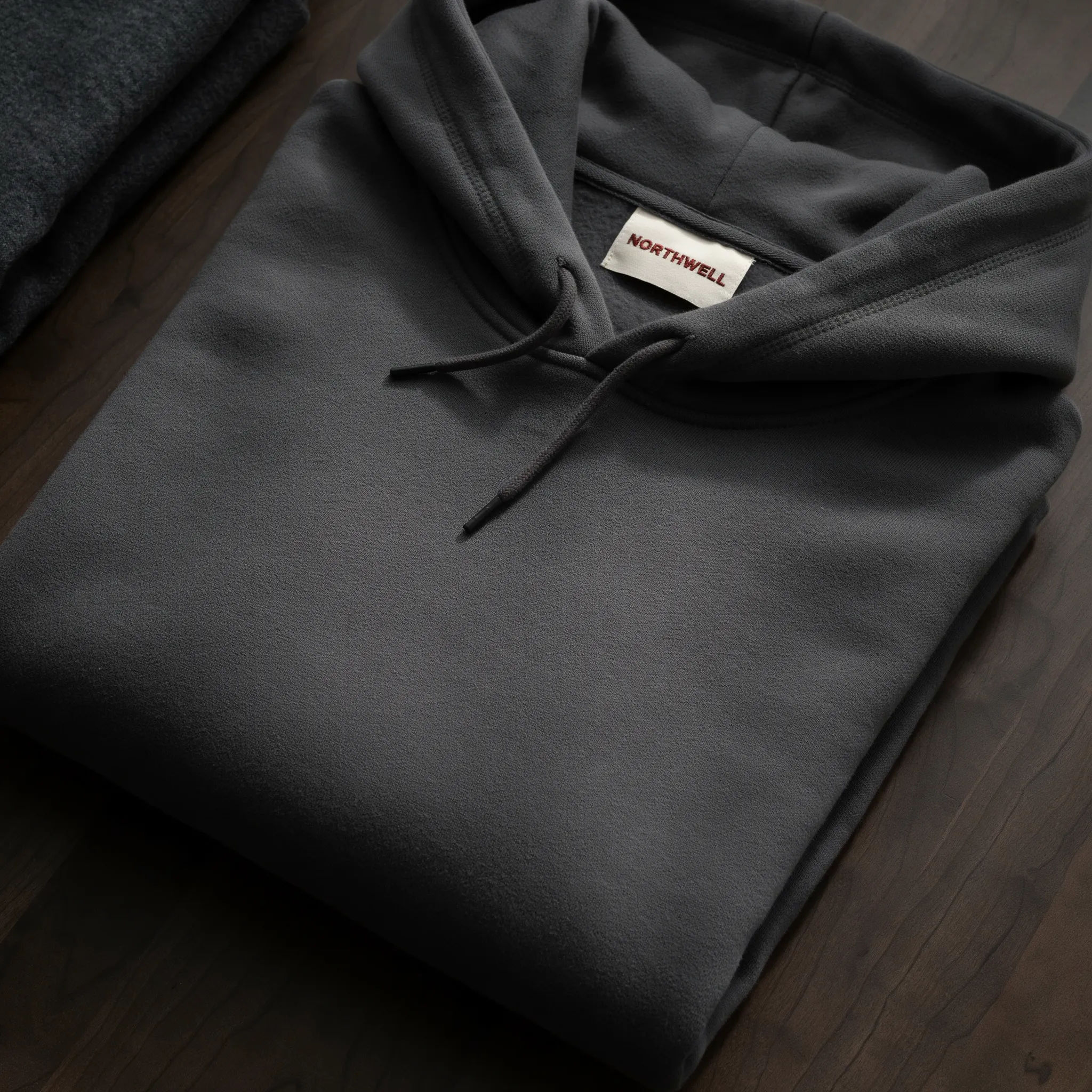 Woven brand label sewn into a folded hoodie