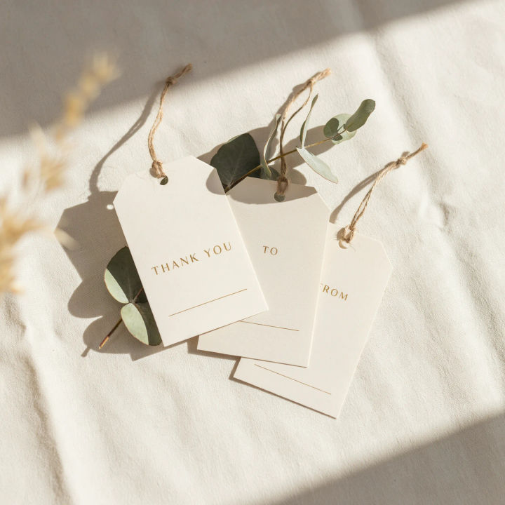 Tags creme de lembrancinha de casamento com eucalipto, detalhes dourados e texto de agradecimento