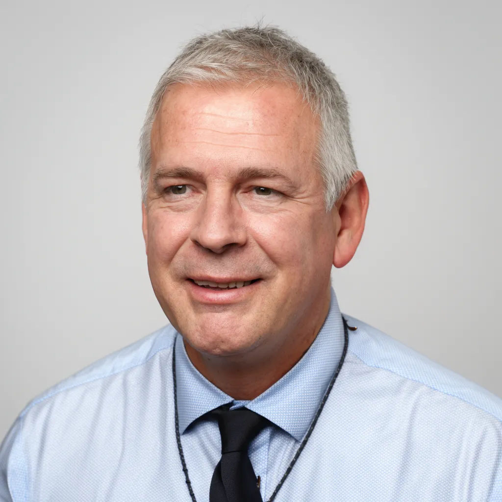 A selfie edited into a professional headshot on a grey studio background