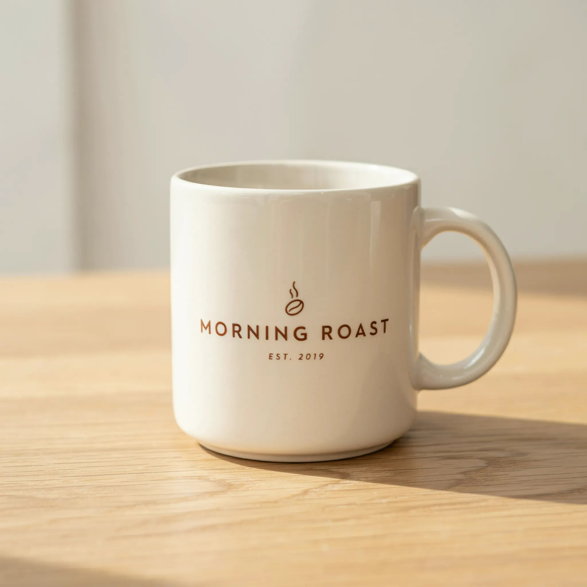 Cream ceramic mug with a minimalist coffee shop logo