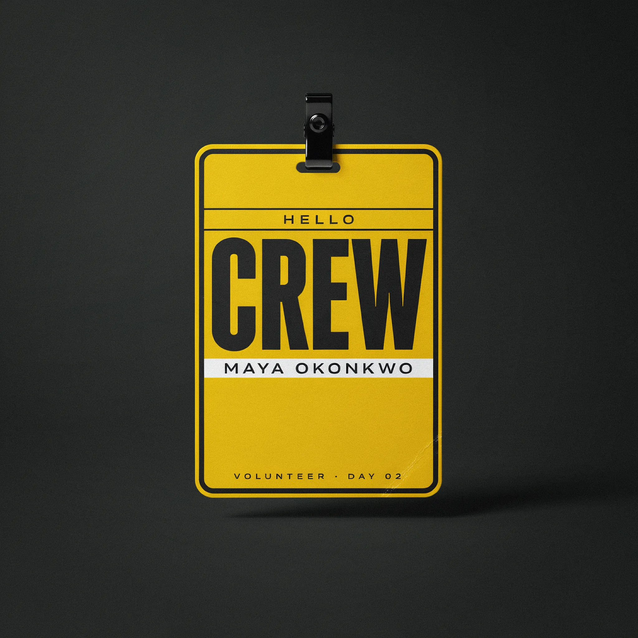 Yellow and black volunteer crew badges with a clear name band
