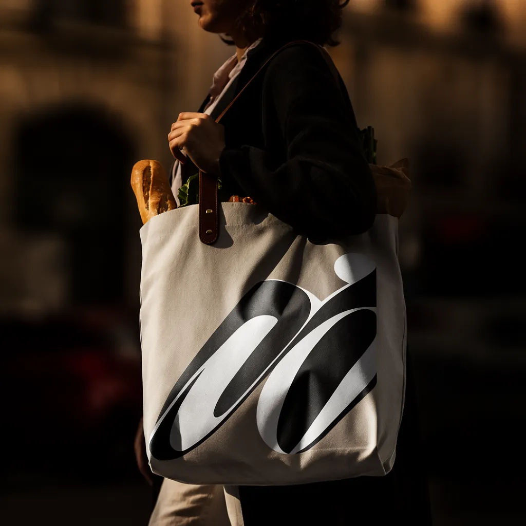 Printed tote filled with groceries carried in afternoon light