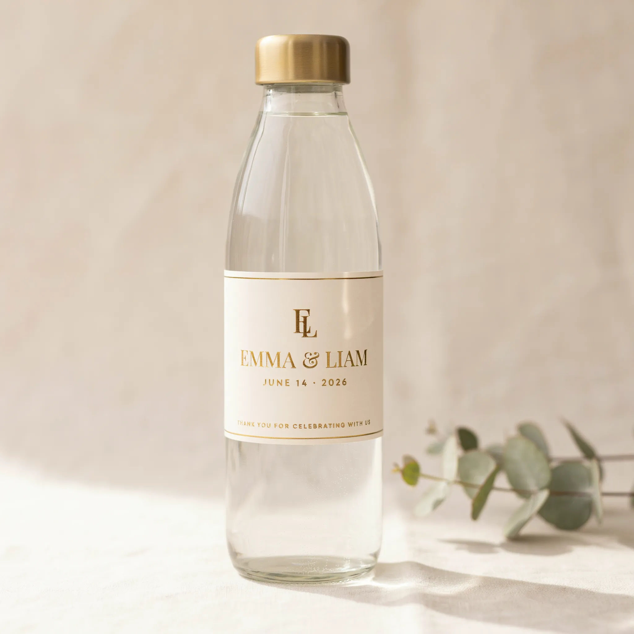 Cream and gold wedding water bottle label wrapped on a clear bottle