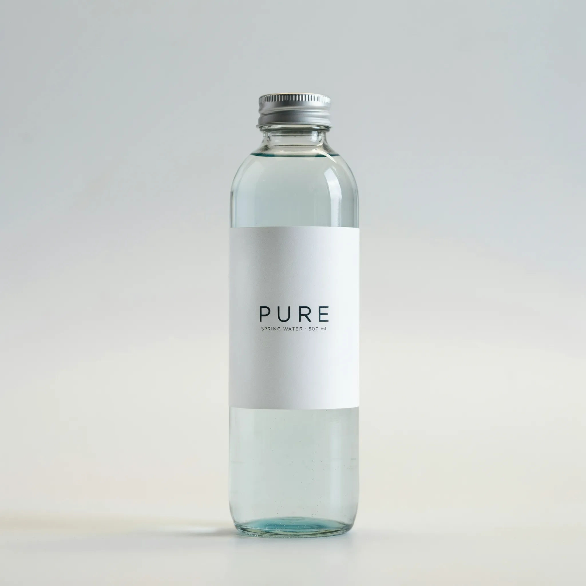 Minimalist white water bottle label with a bold navy brand name