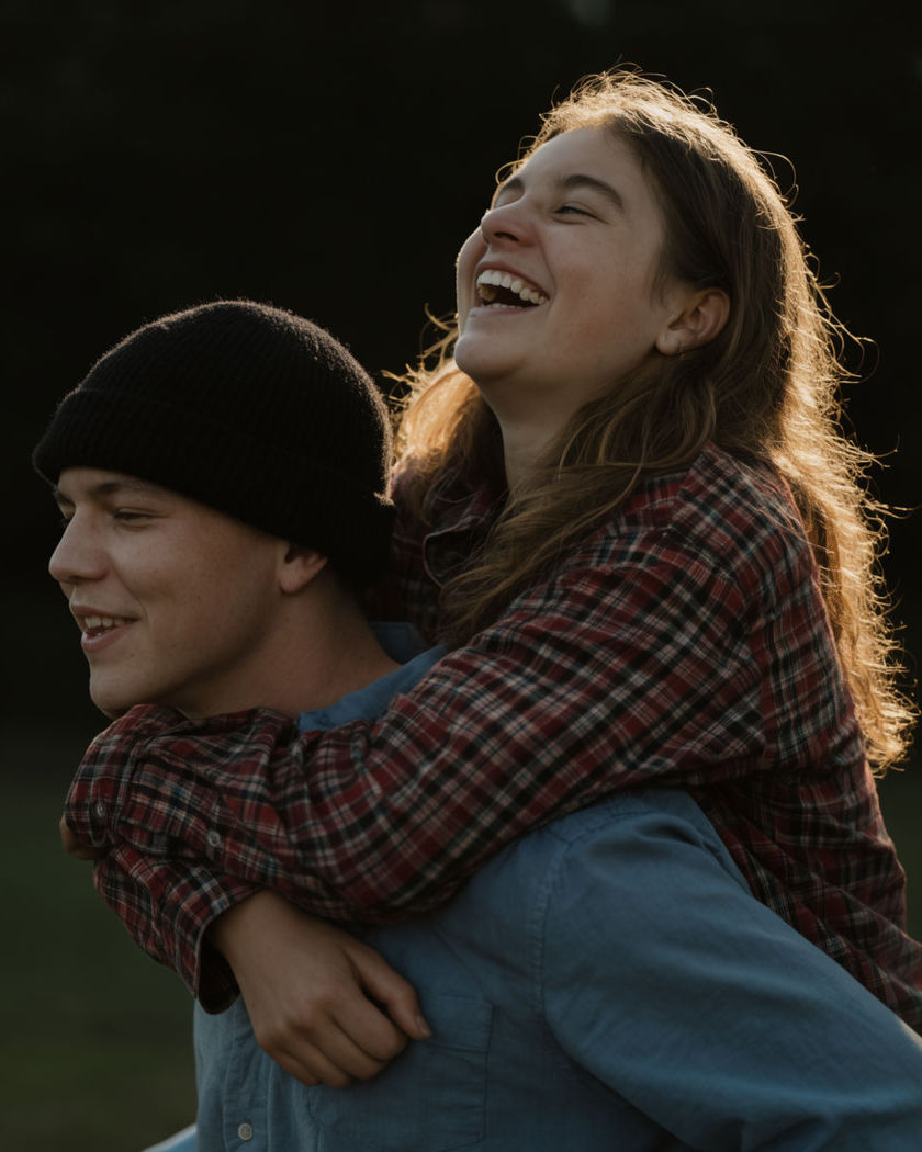 One person giving another a laughing piggyback ride outdoors