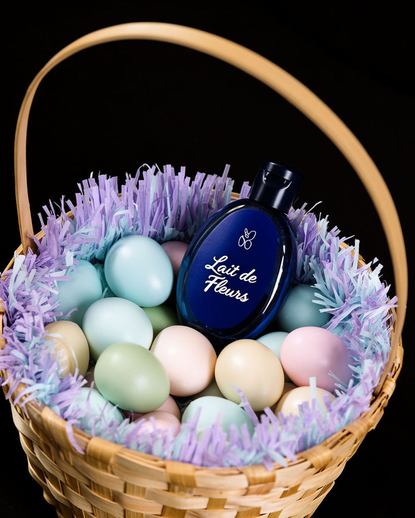 A product nestled inside a woven Easter basket among pastel eggs and paper grass in soft spring light