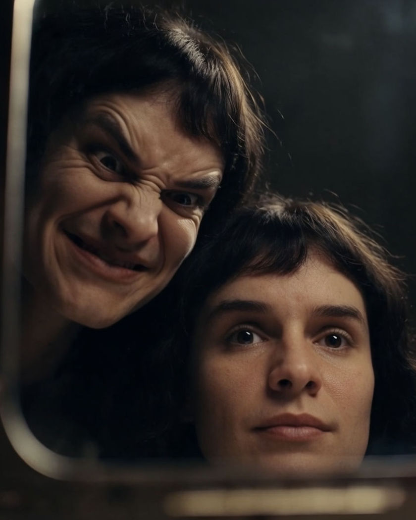 A calm face reflected in a mirror as the reflection turns sinister a beat behind the real motion