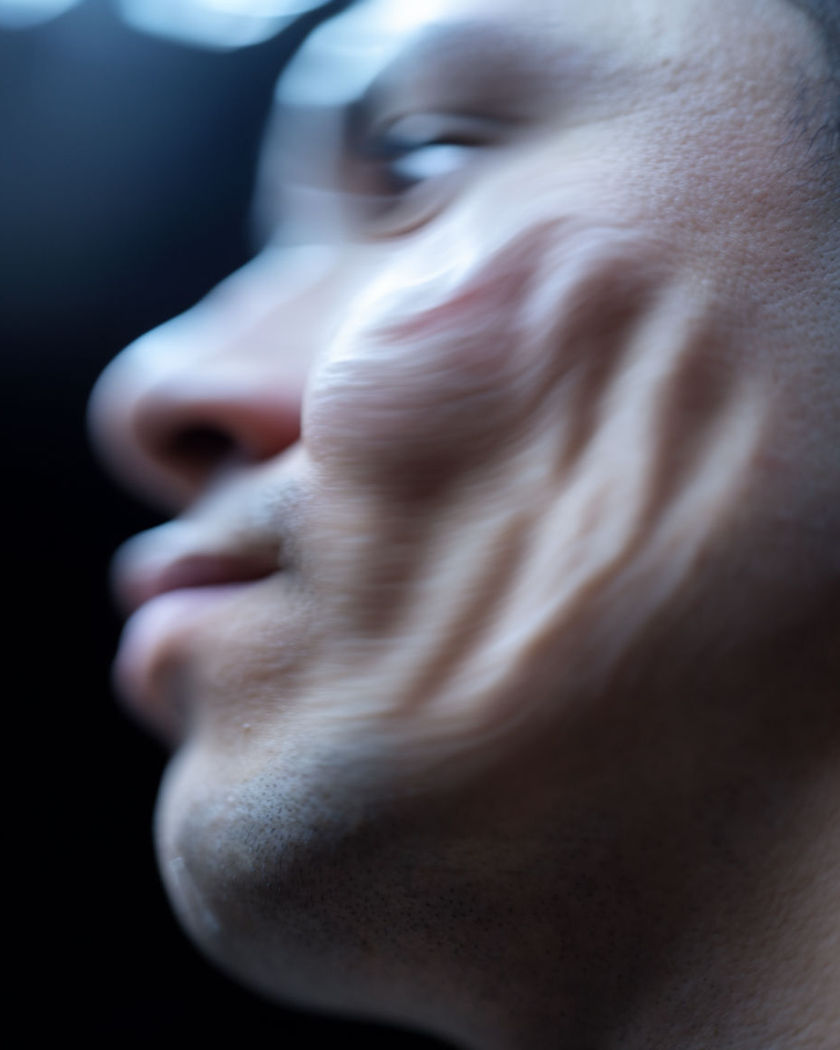 A face frozen mid comedic wobble, an exaggerated cartoon ripple frozen across the cheek