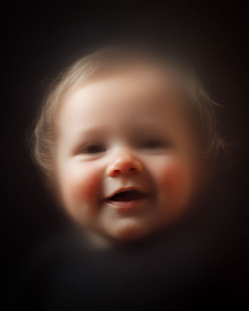 A soft blended portrait resolving into a generated baby face smiling gently in warm natural light