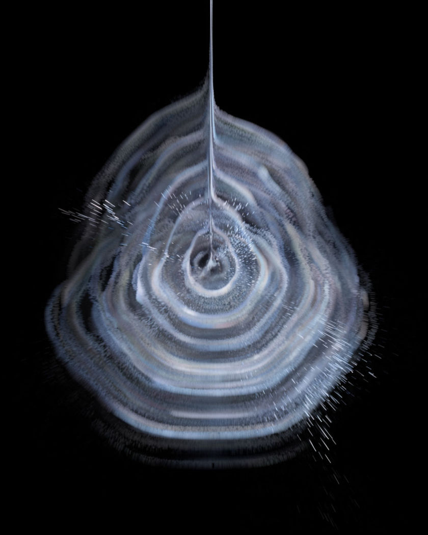 Rings of soft light spreading outward across a dark surface from a central point on a black ground