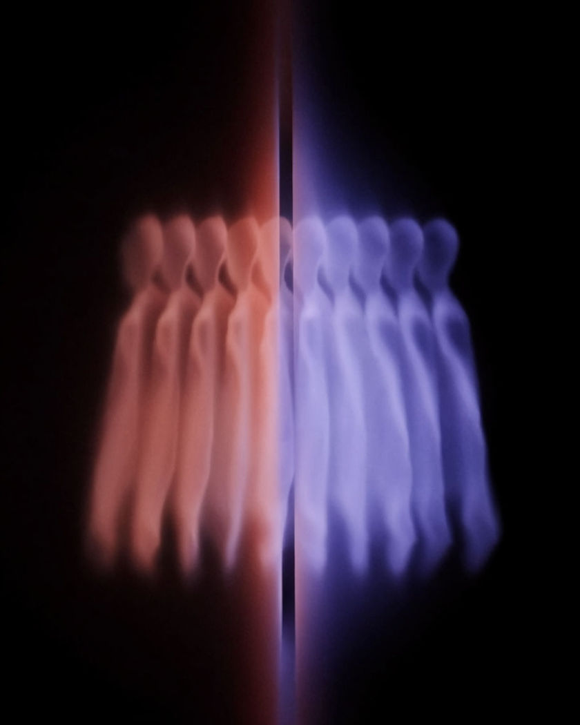 A glowing slot emitting a row of identical soft silhouettes fanning outward against a pure black ground