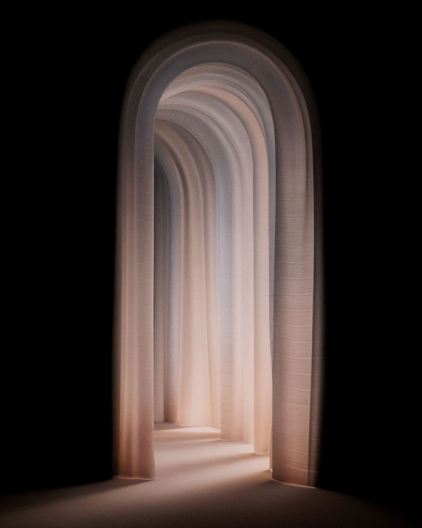 A luminous corridor of tall arches receding into soft depth with warm light pooling on the floor against a near-black ground