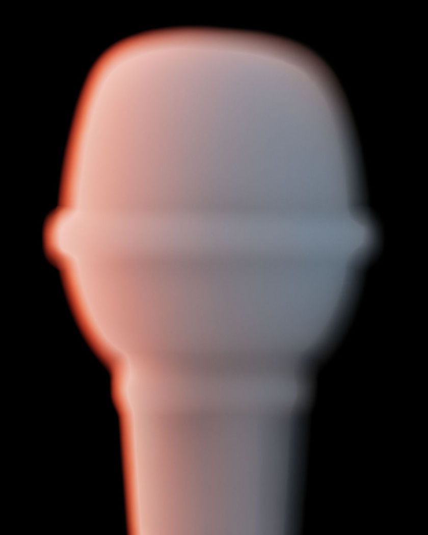 A softly lit foam-topped microphone glowing against a black ground with a warm rim of light