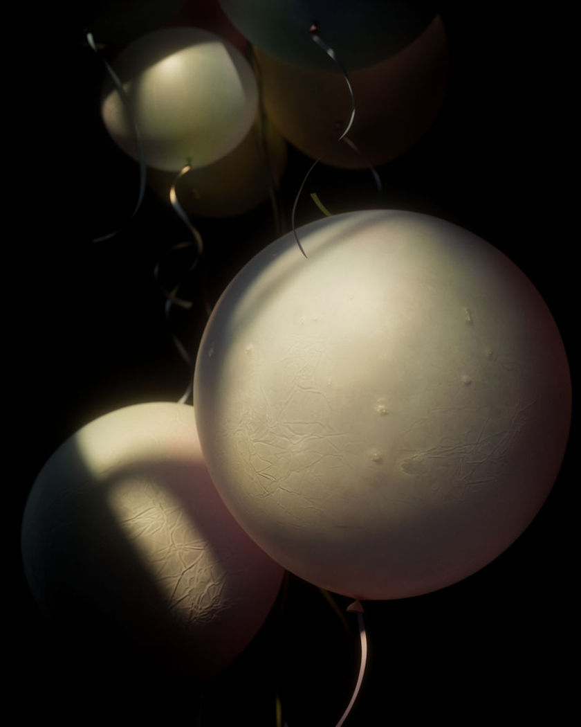 A cluster of round balloons rising on thin curling ribbons on a black ground