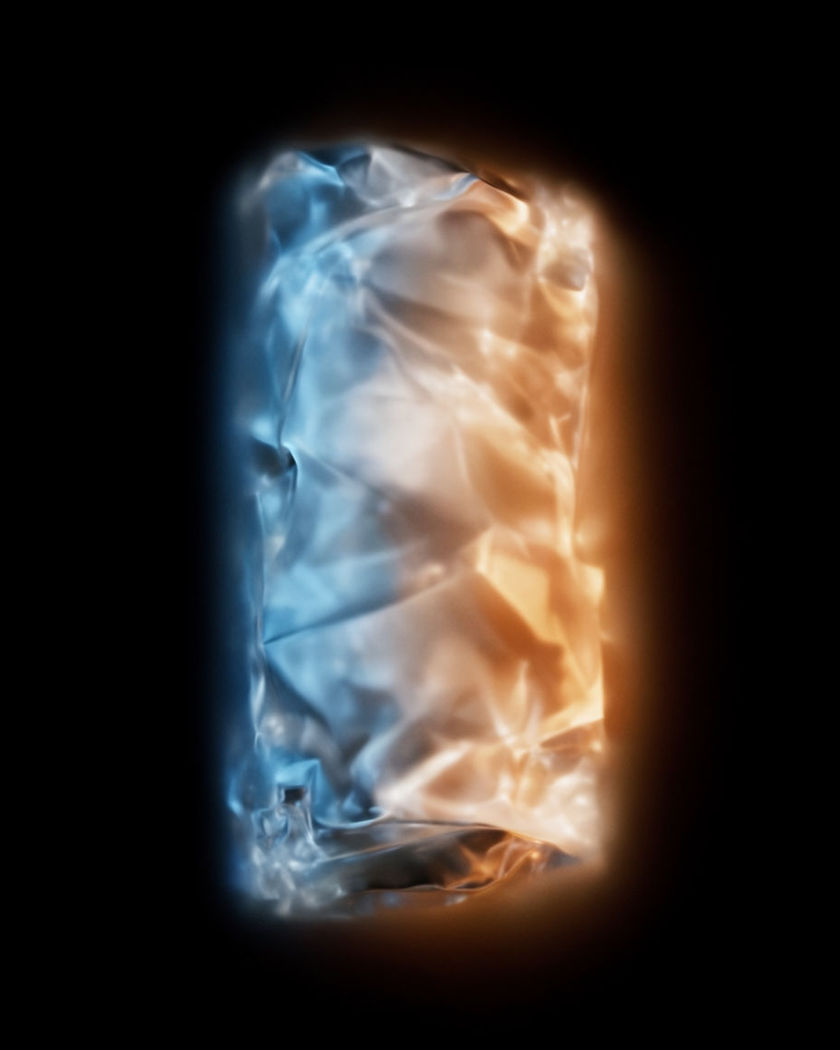 A single luminous product silhouette lit by a sweeping beam of light on a pure black ground, no text
