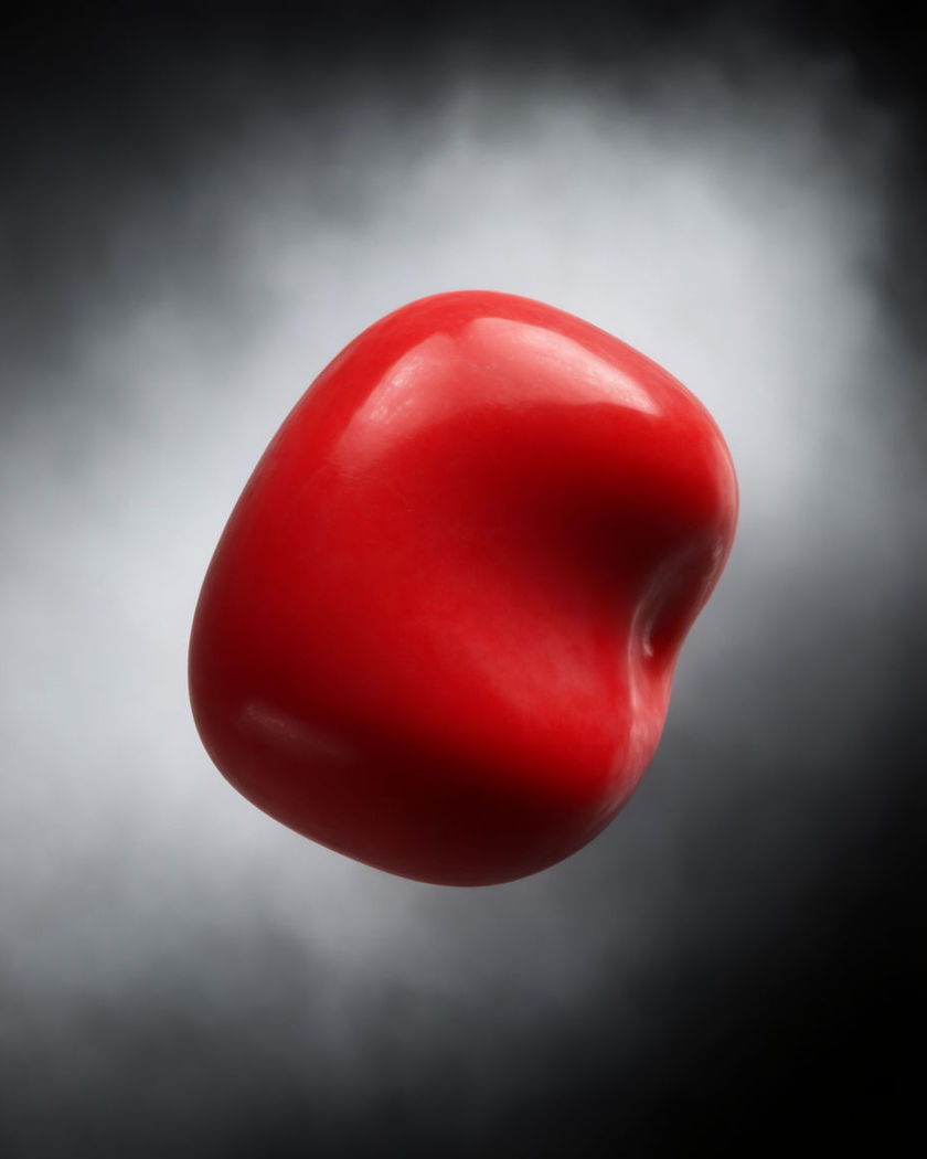 A single red object glowing with full color in the center of an otherwise grayscale frame