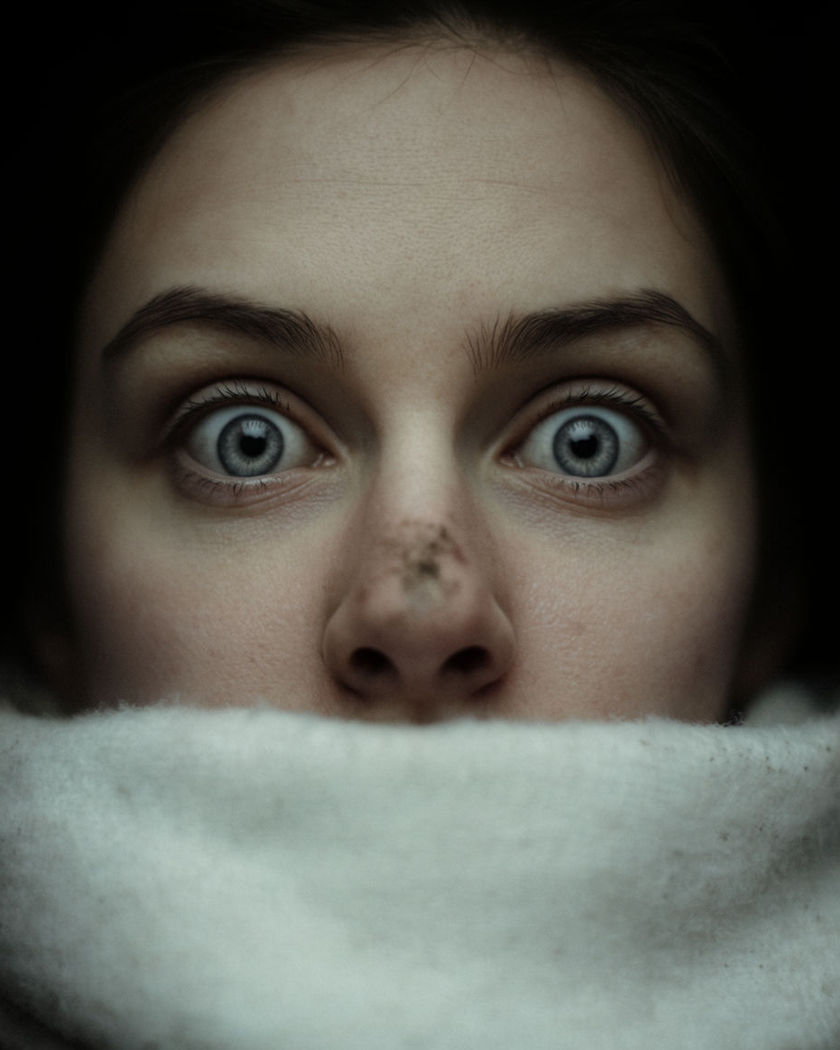 A close winter portrait with the eyes held pin sharp while a scarf and snowy background gently resolve into focus