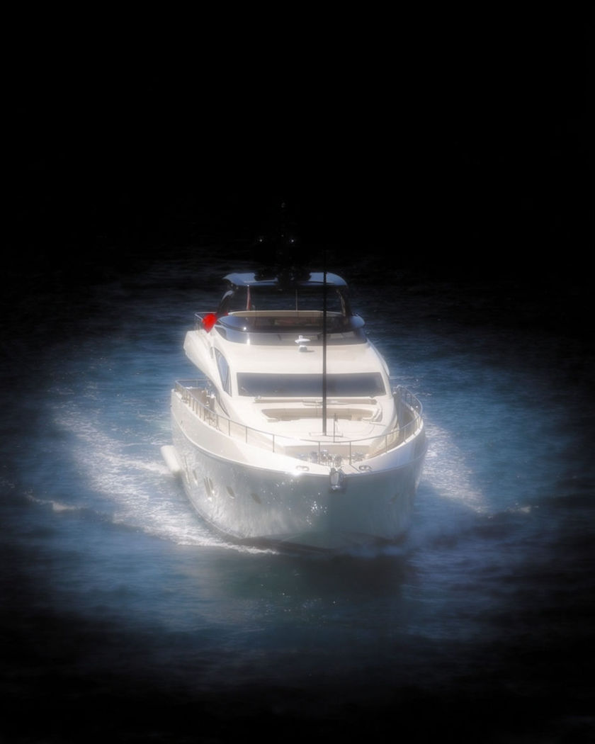 A gleaming white private yacht carving a bright wake across deep blue water under strong sun on a black ground